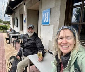 Philip and Laura sitting at an outdoor café along the Camino de Santiago, resting during the walk while enjoying a drink.