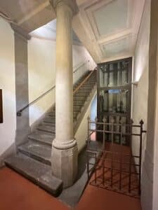 Entrance foyer of our Florence apartment with a stone staircase and a small European elevator providing access to the upper floors.