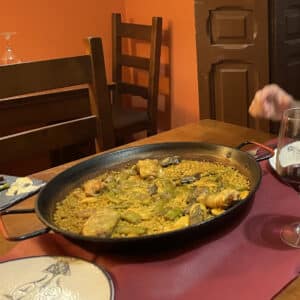 Traditional Paella Valenciana served in a wide pan with chicken, green beans, and saffron rice in Valencia.