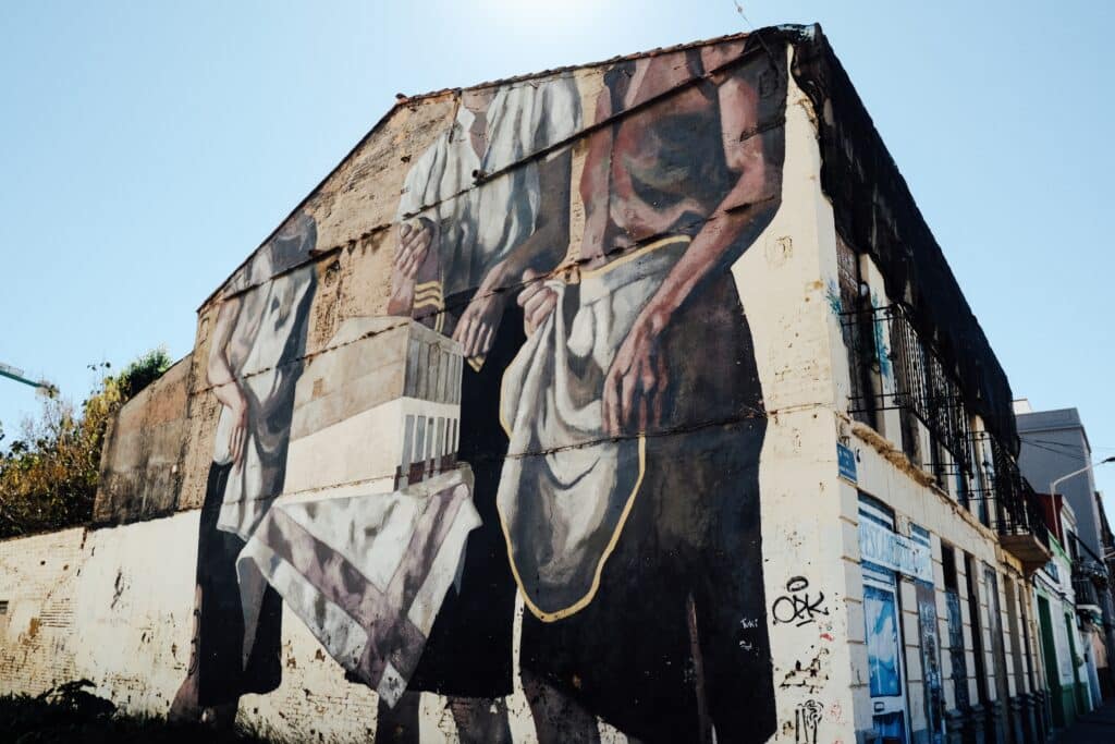 Cabanyal street mural painted on a weathered building, showcasing the neighborhood’s blend of history and local creativity in one of the cultural things to do in Valencia.