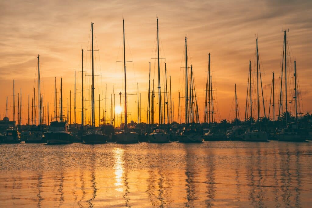 Sunset over sailboats in La Marina de València, a relaxing waterfront spot and one of the scenic things to do in Valencia.
