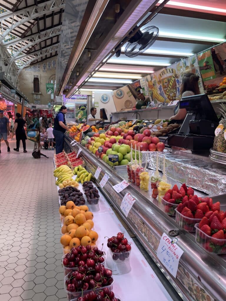 Colorful fruit stalls inside Mercado Central in Valencia, showcasing fresh produce and the lively atmosphere of one of the must-see things to do in Valencia.