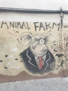 Street art mural in Ruzafa, Valencia, showing Animal Farm–inspired imagery in a neighborhood popular for food and local life when deciding where to stay in Valencia.