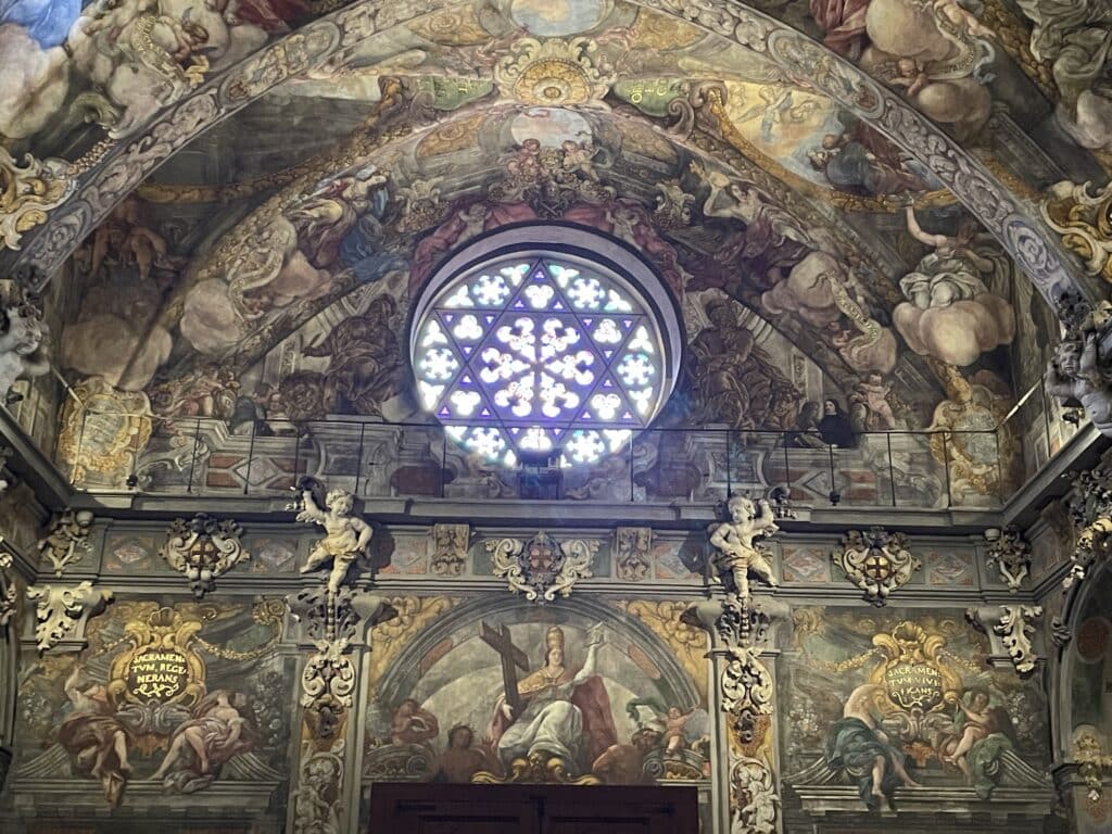 Fresco-covered vaults and the Star of David Rose Window inside Iglesia de San Nicolás, one of the most remarkable artistic things to do in Valencia.